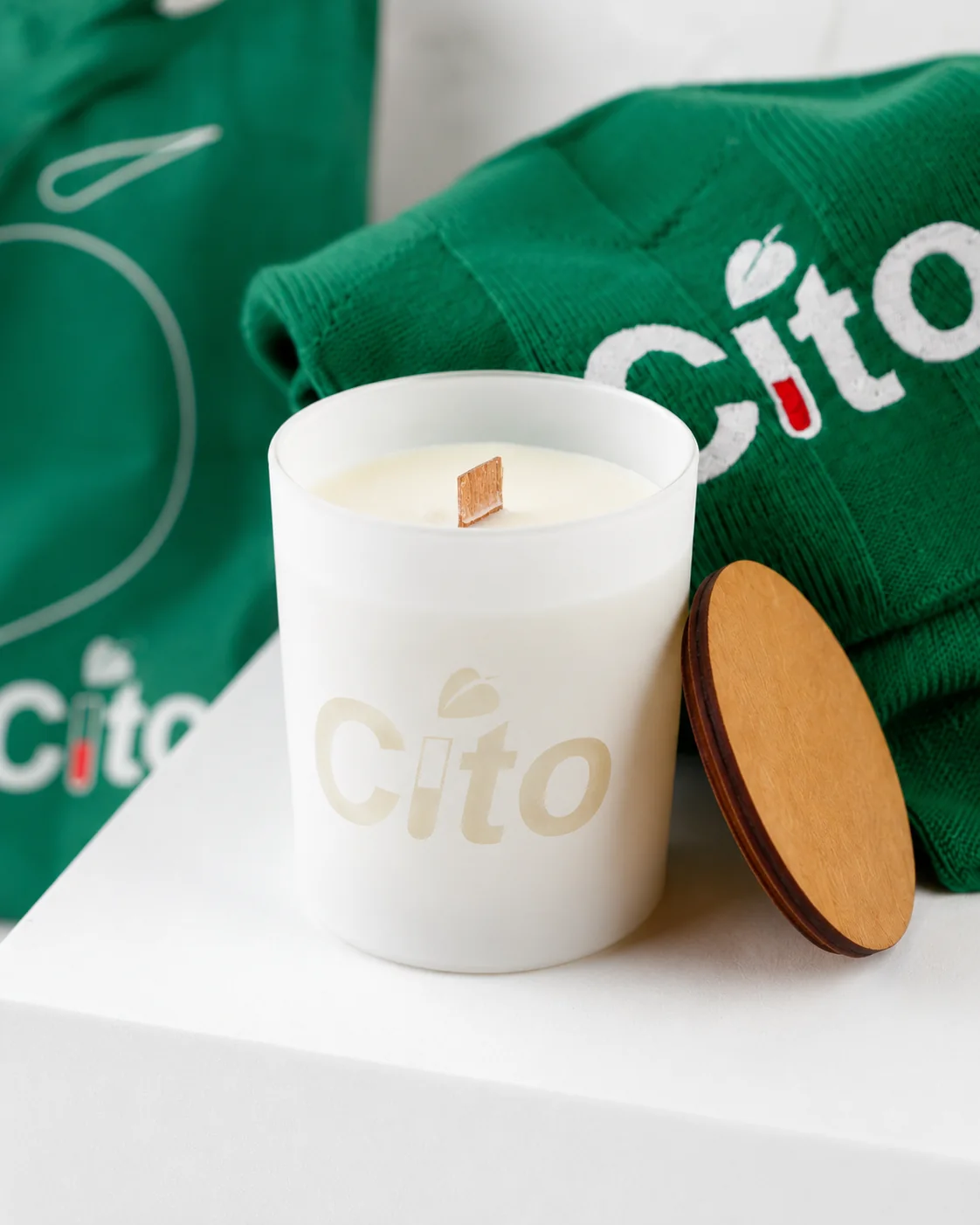 Ароматическая свеча Cito с гравировкой рядом с пледом и шоппером