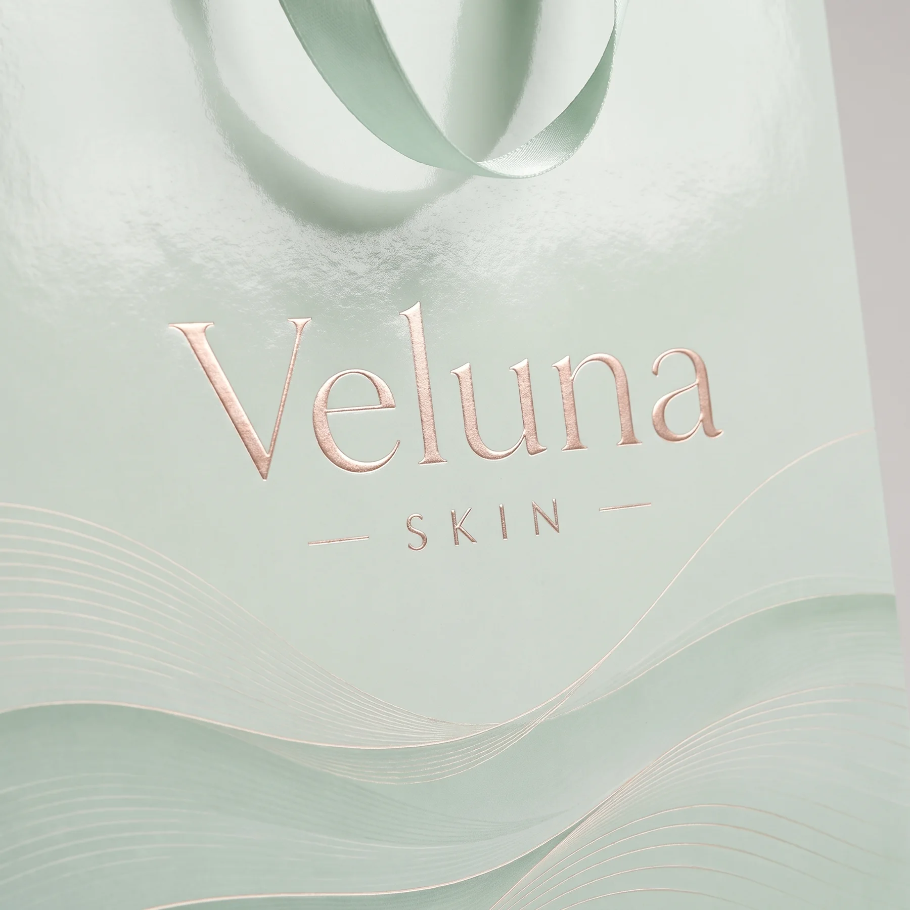 Золотое тиснение логотипа Veluna Skin на мятном пакете